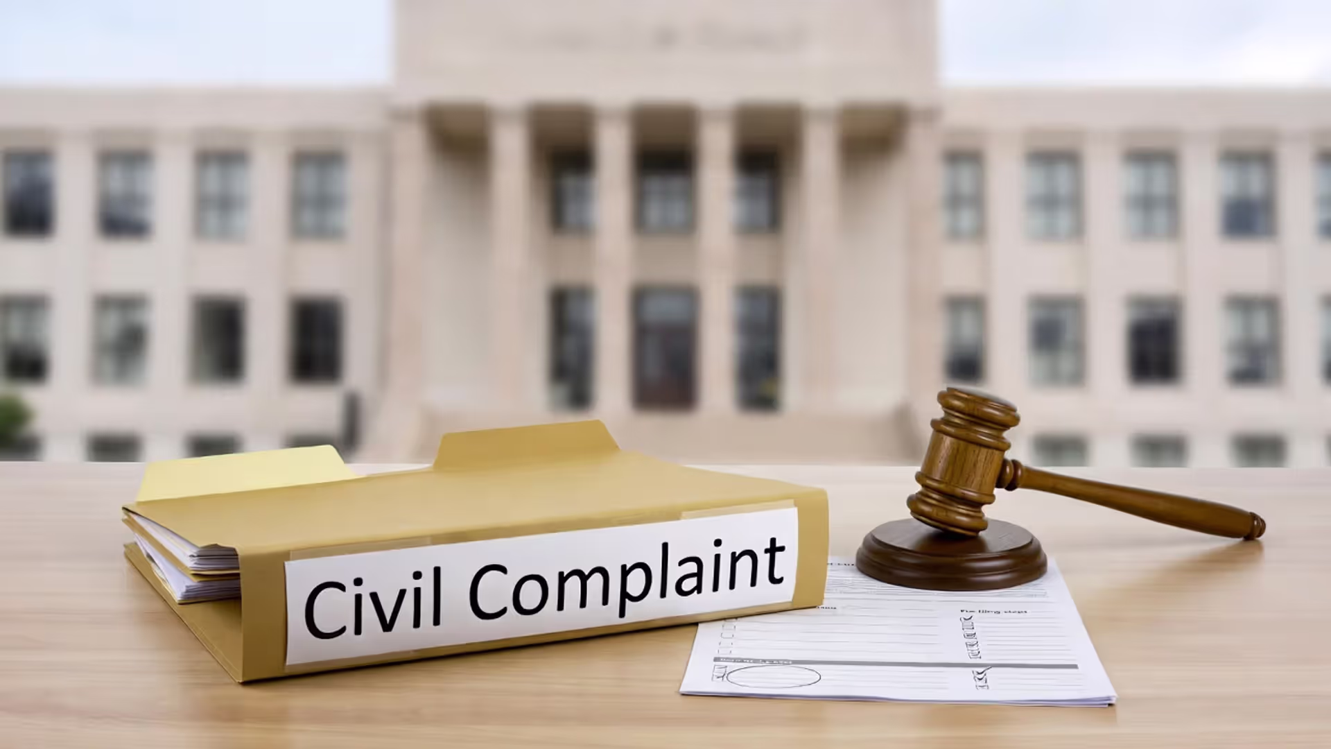 Desk with a civil complaint folder, calendar with a circled date, and a pre-filing checklist.