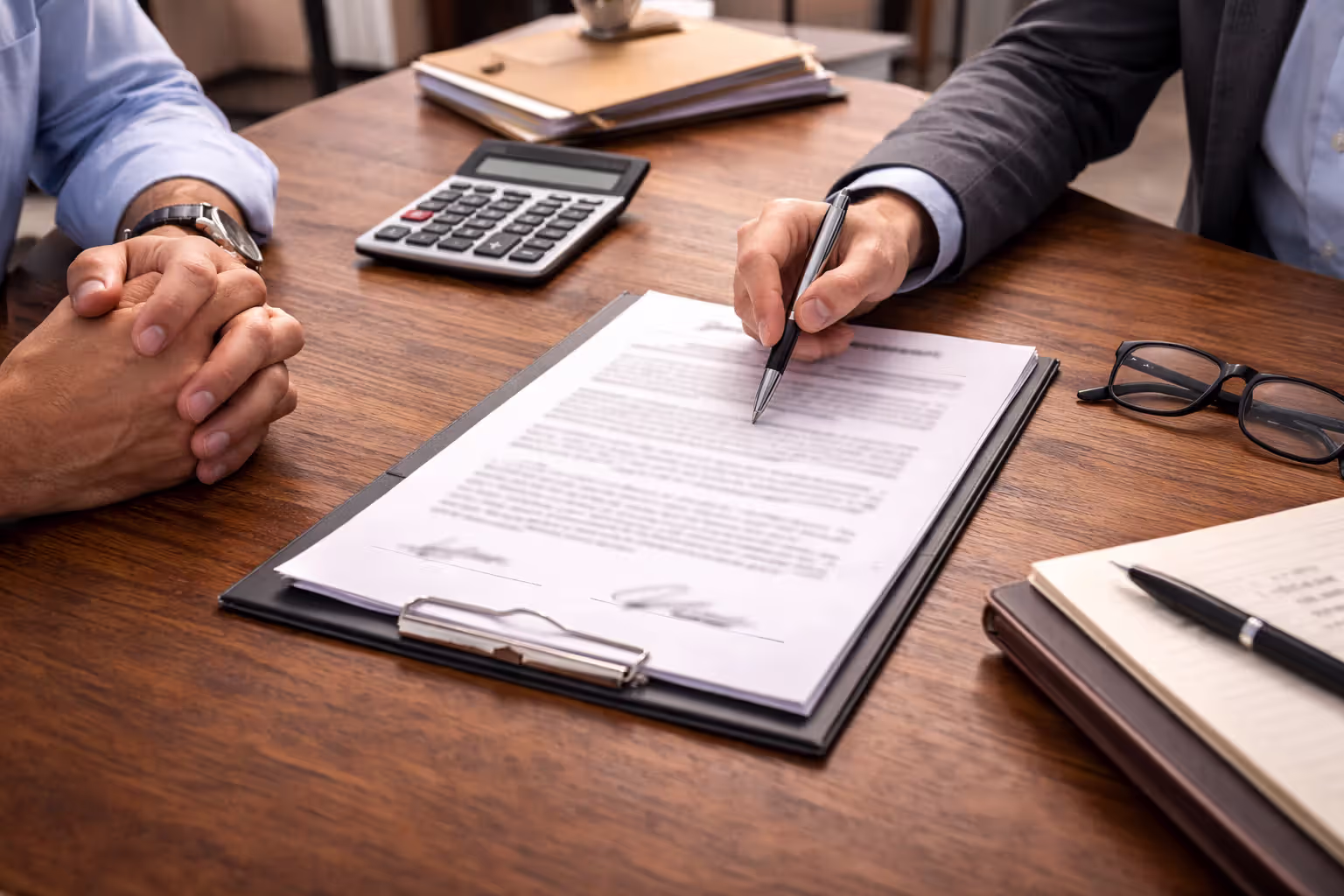 Business partners reviewing buy-sell clause and valuation terms in agreement